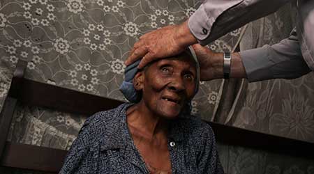 a woman with priests hands on her head